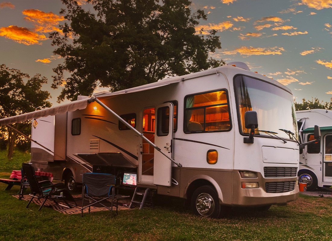 Insurance Solutions - Sun Going Down at an RV Park With Lights on the Motor Home
